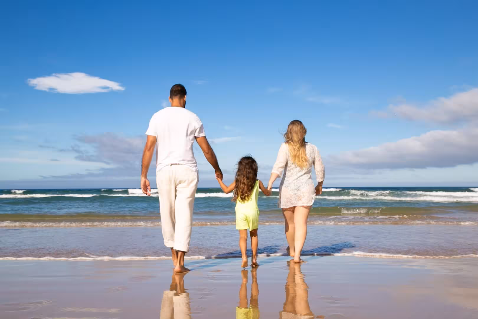 Family walking on beach — global lifestyle